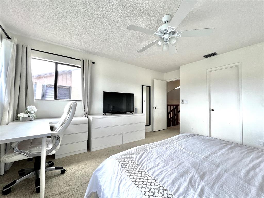 7750 Northwest 79th Avenue, Unit H5 Tamarac, FL 33321 - Photo 18 of 28 a bedroom with a bed and a flat screen tv