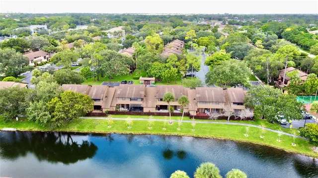 an aerial view of a house with a garden and lake view