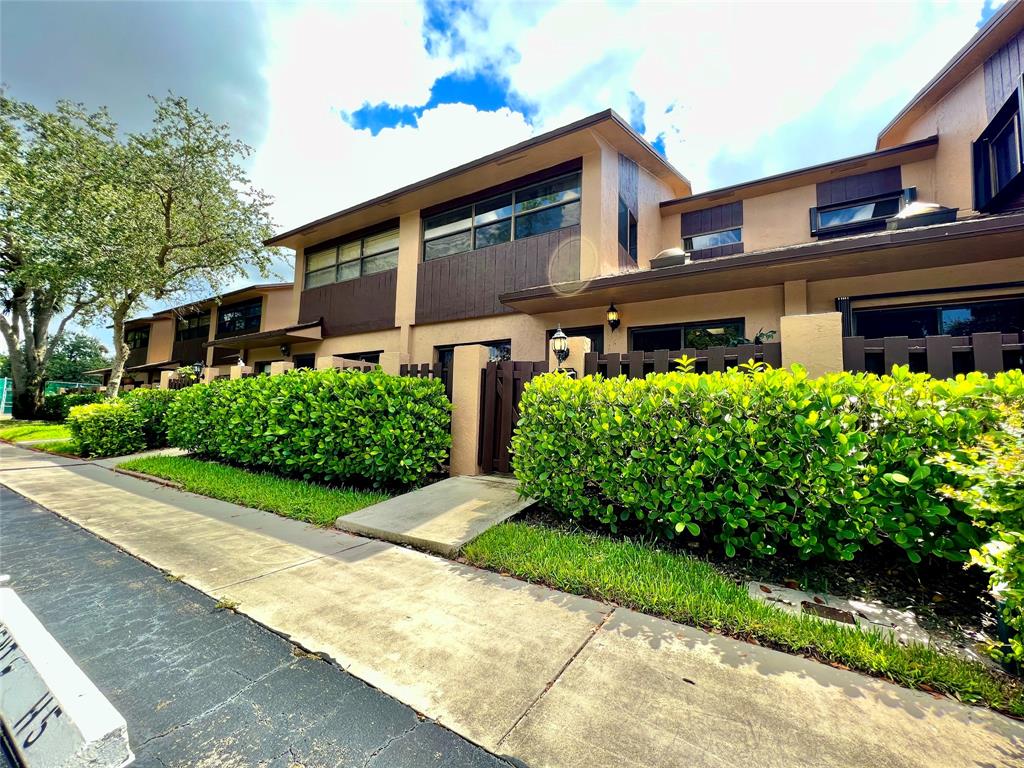 7750 Northwest 79th Avenue, Unit H5 Tamarac, FL 33321 - Photo 4 of 28 a front view of a house with a yard