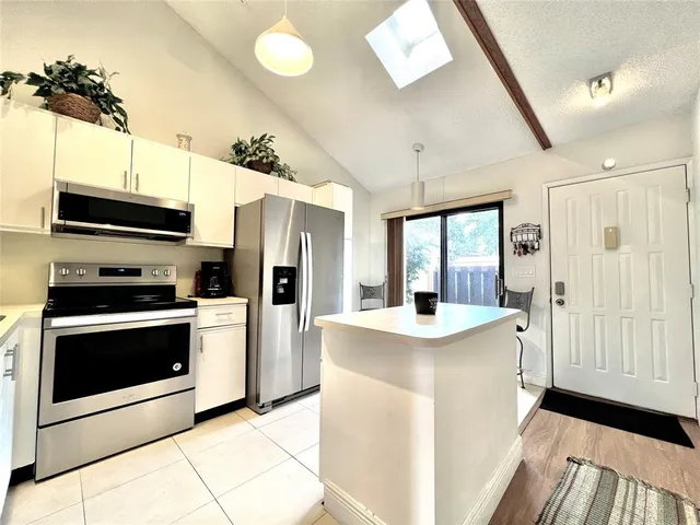 a kitchen with stainless steel appliances a stove microwave and a refrigerator