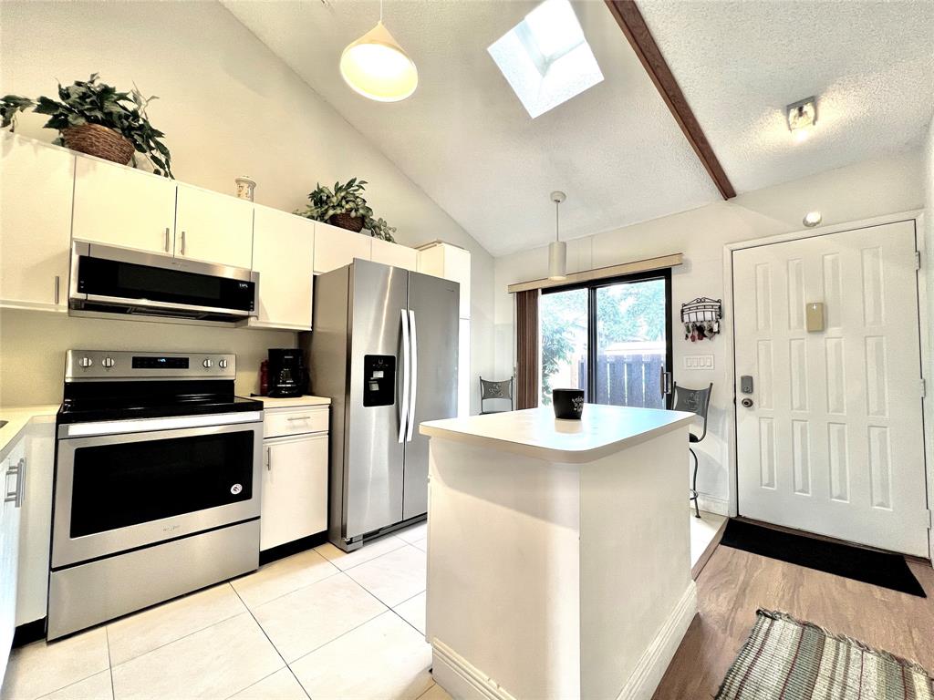 7750 Northwest 79th Avenue, Unit H5 Tamarac, FL 33321 - Photo 10 of 28 a kitchen with stainless steel appliances a stove microwave and a refrigerator