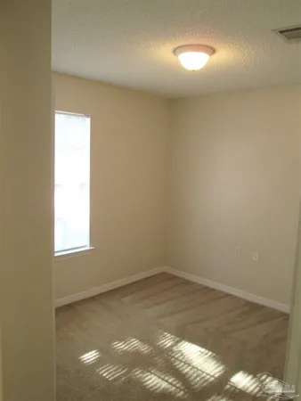 an empty room with wooden floor and windows in it
