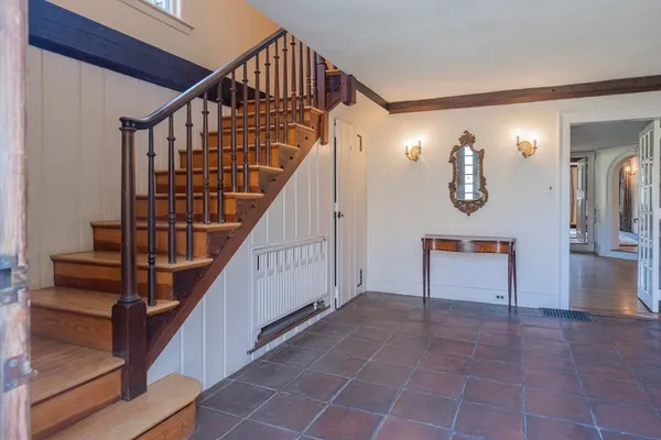 a view of staircase with lots of frames on wall and a window