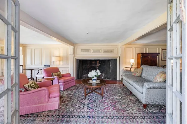 a living room with furniture fireplace and a large window