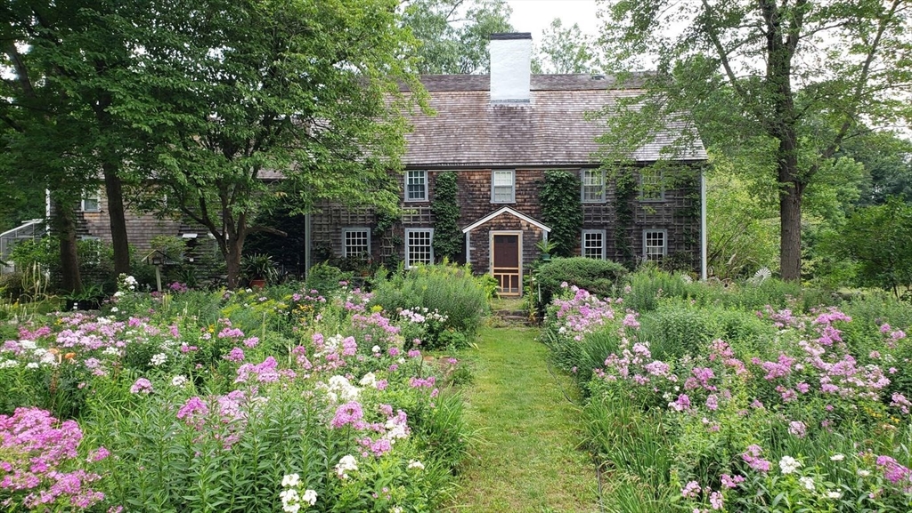 9 Maple Street Wenham, MA 01984 - Photo 42 of 42 a front view of a house with lots of flower and trees