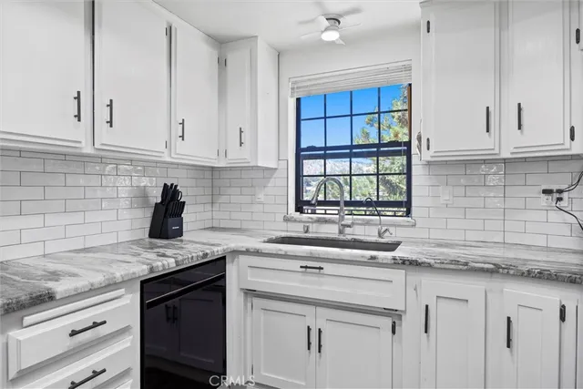 a kitchen with granite countertop white cabinets and white appliances