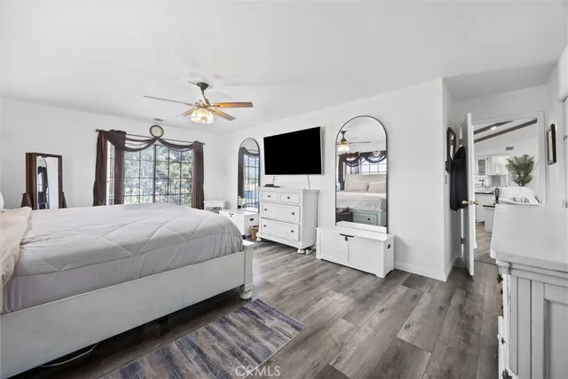 a spacious bedroom with a bed a flat screen tv and a fireplace