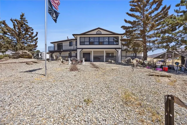 a front view of a building with large trees