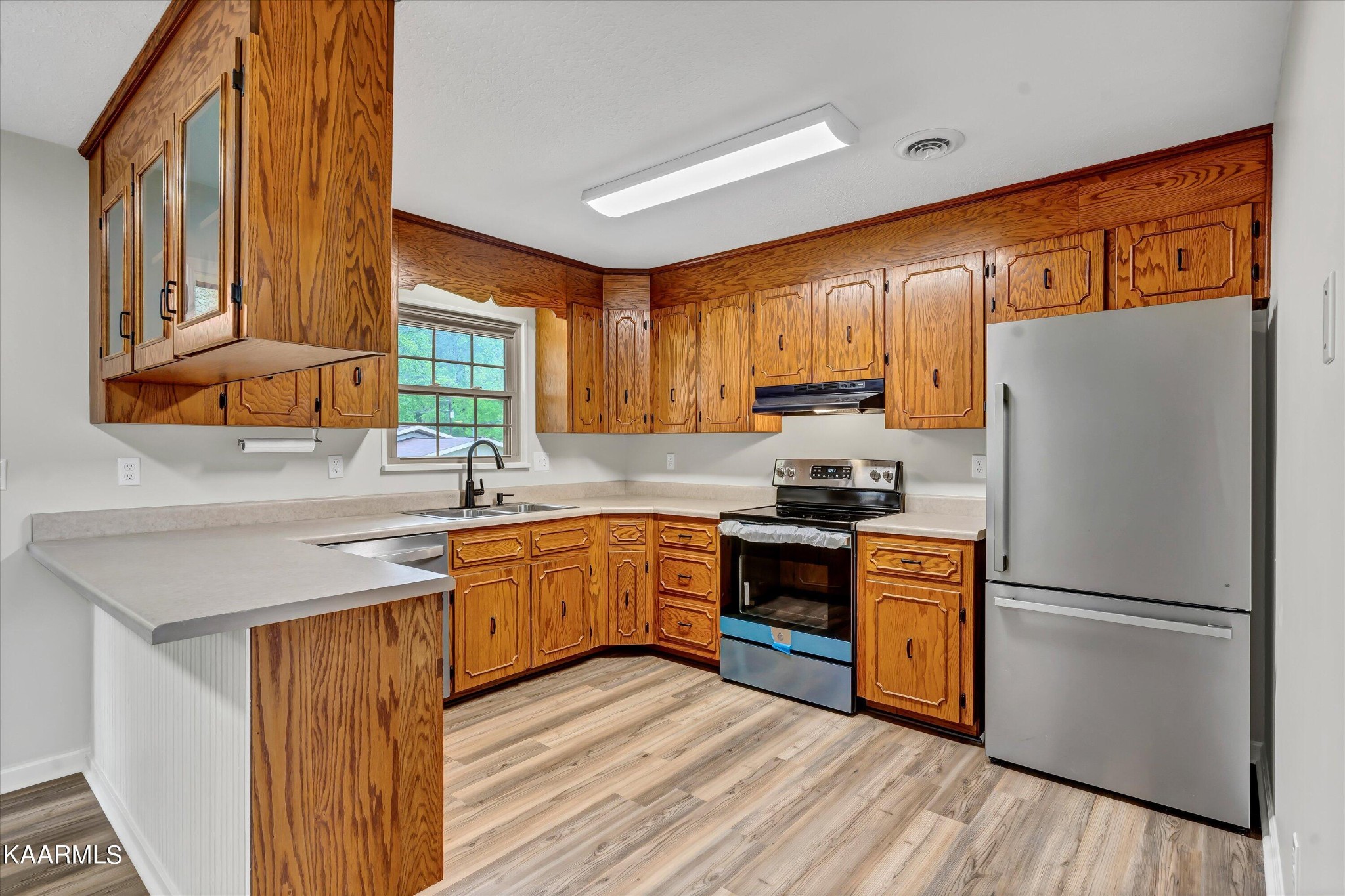 615 Kings Row Sevierville, TN 37863 - Photo 7 of 26 a kitchen with stainless steel appliances granite countertop a refrigerator a sink dishwasher a stove with wooden cabinets and floor