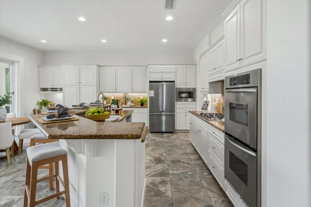 a spacious en suite bathroom with a granite countertop tub sink and mirror