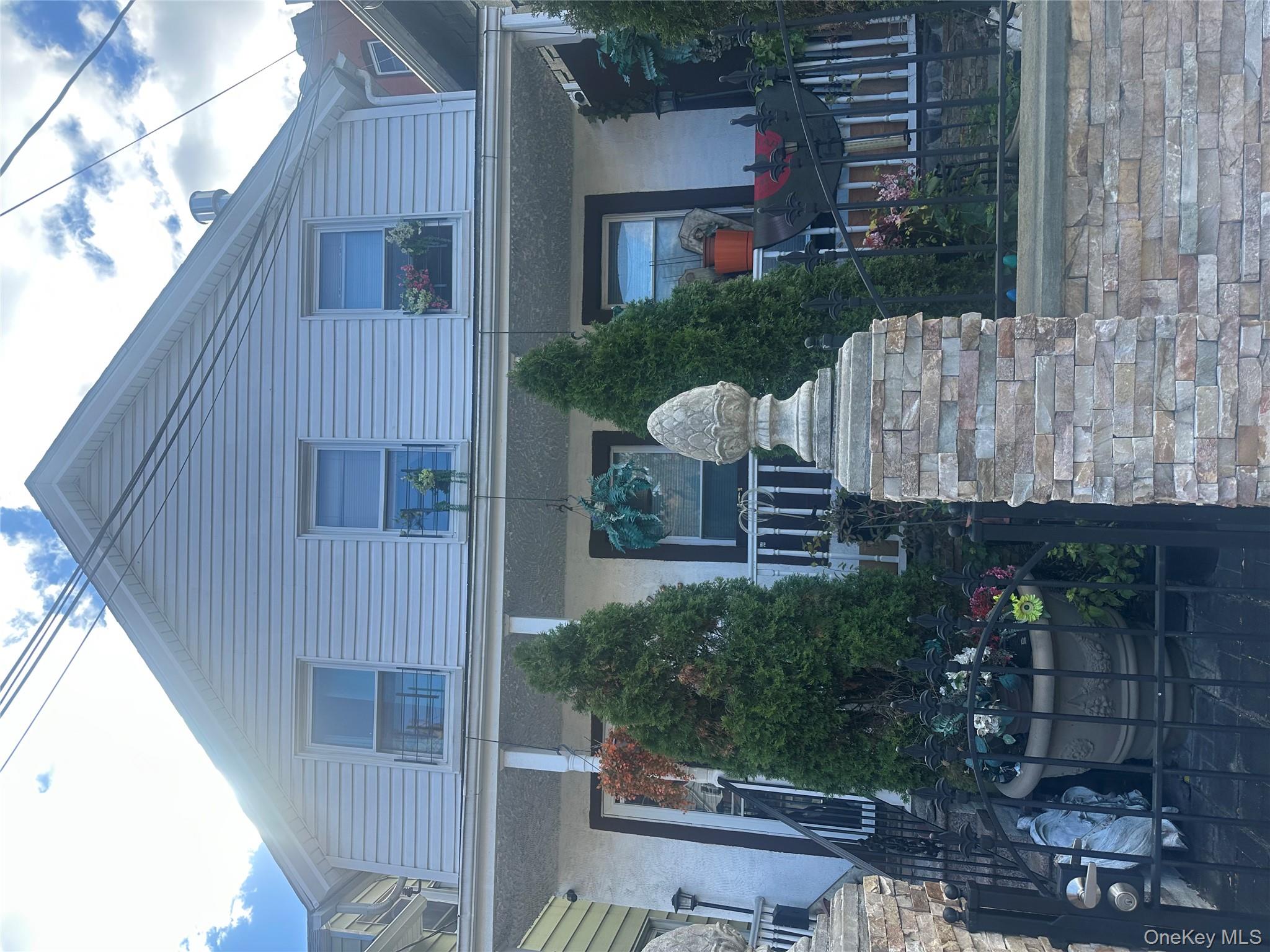 87 McLean Avenue Yonkers, NY 10705 - Photo 1 of 3 a front view of a house with garden