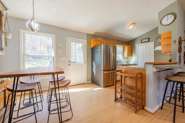 a kitchen with stainless steel appliances granite countertop a refrigerator and a stove top oven