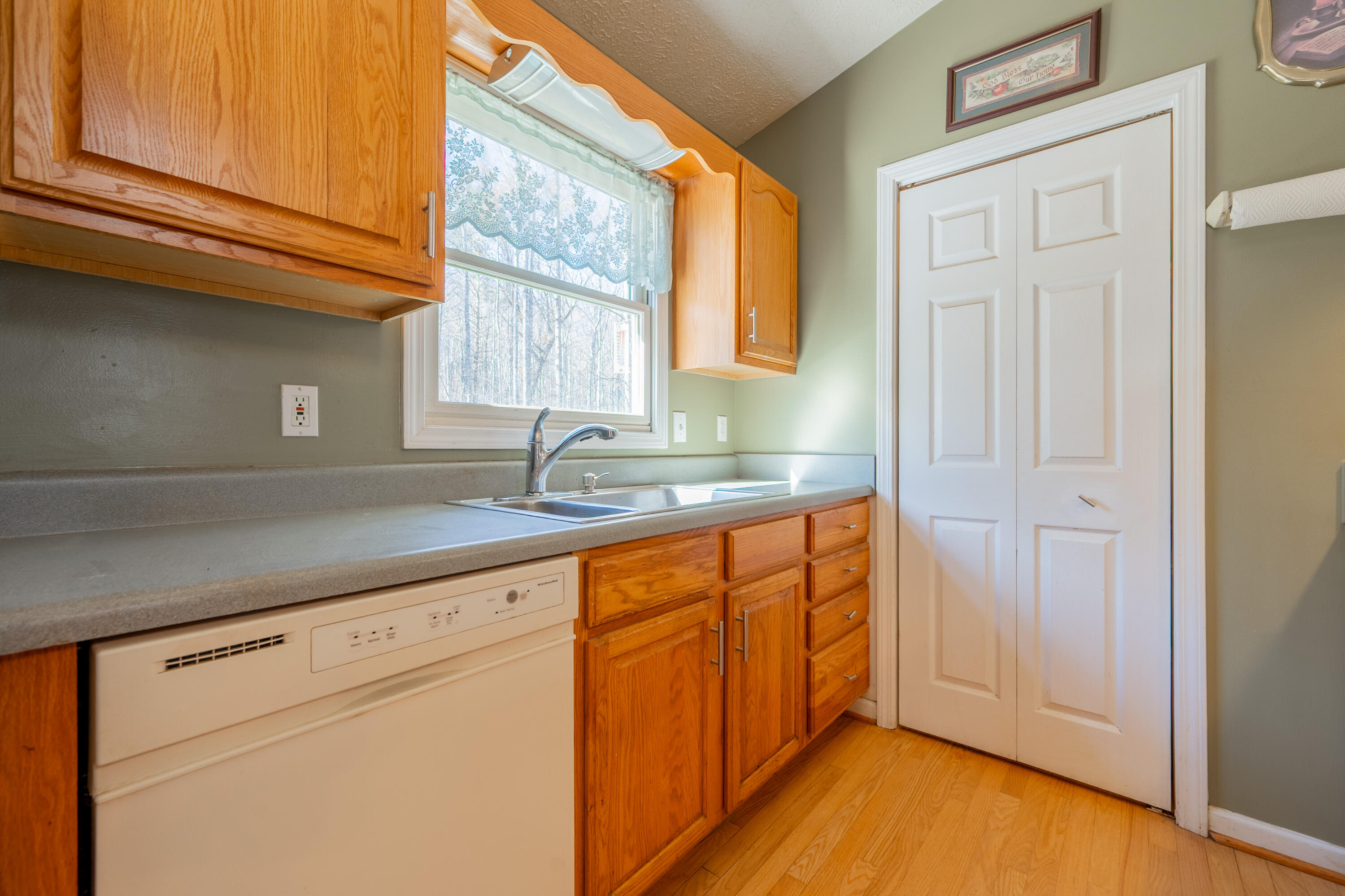 1126 Duncans Chapel Road Northwest Willis, VA 24380 - Photo 13 of 74 a kitchen with stainless steel appliances granite countertop a sink and cabinets with wooden floor