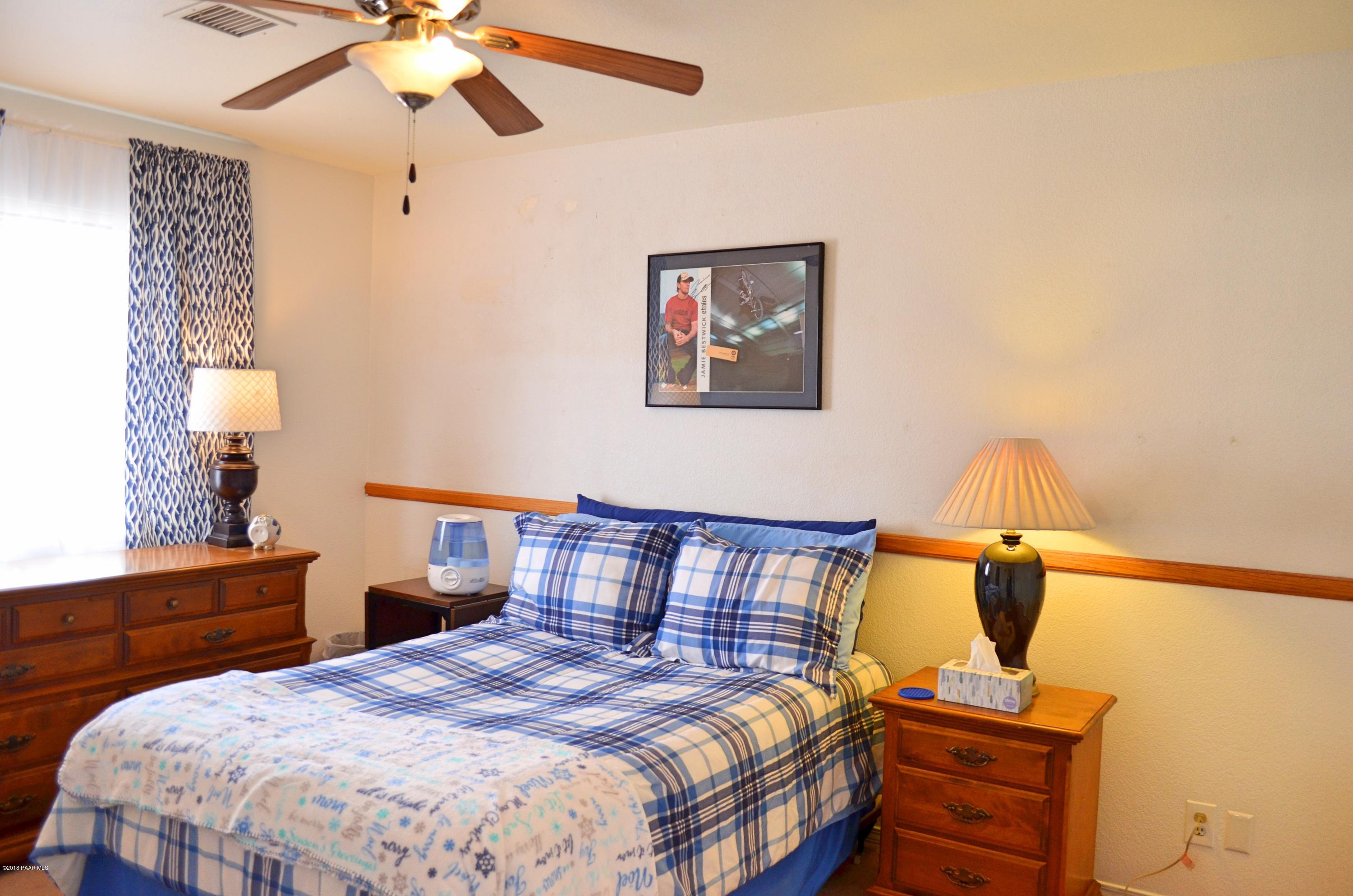 4660 North Miner Road Prescott Valley, AZ 86314 - Photo 14 of 20 a bedroom with a bed and a chandelier