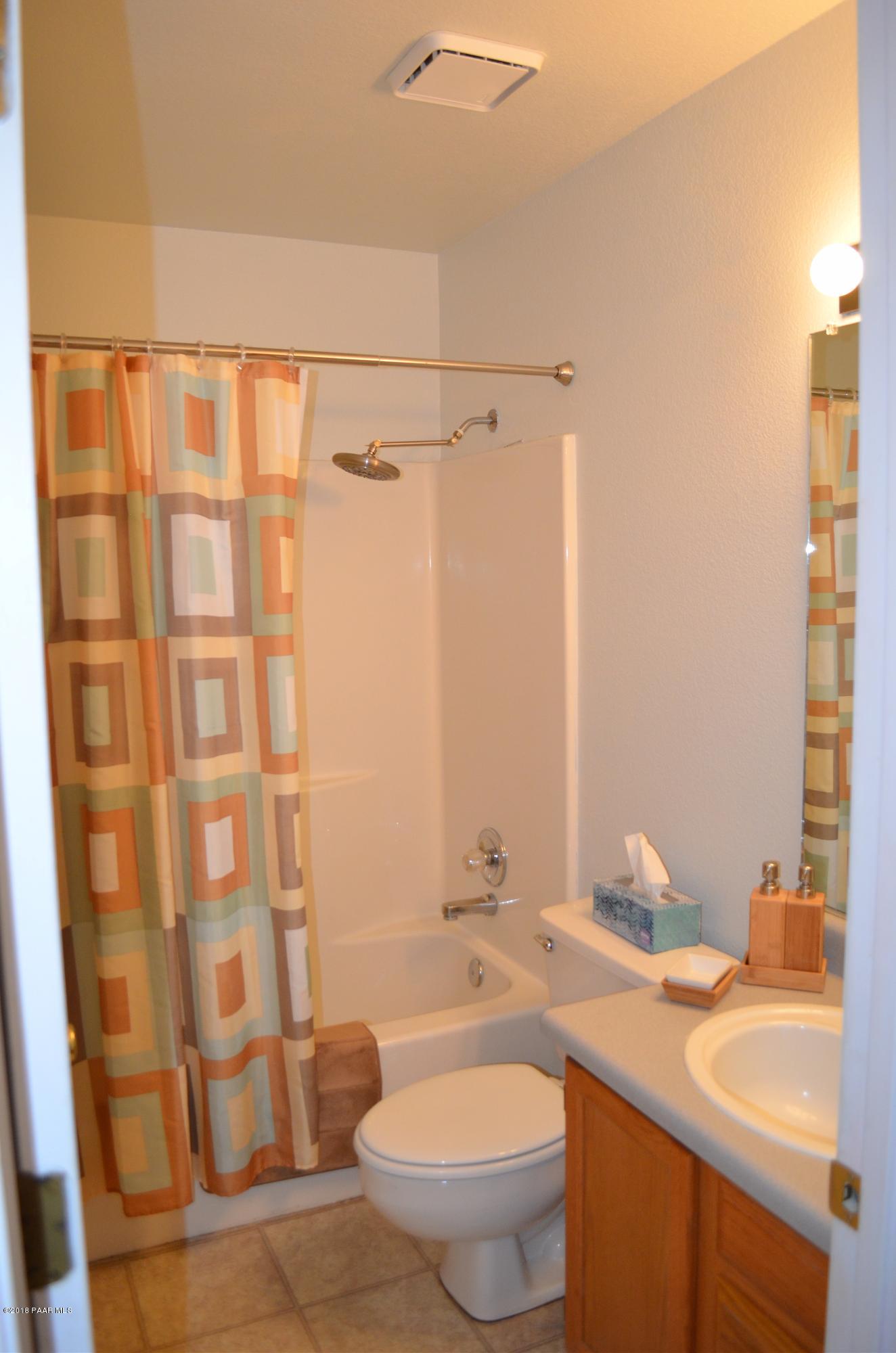 4660 North Miner Road Prescott Valley, AZ 86314 - Photo 15 of 20 a bathroom with a sink a toilet and shower curtain
