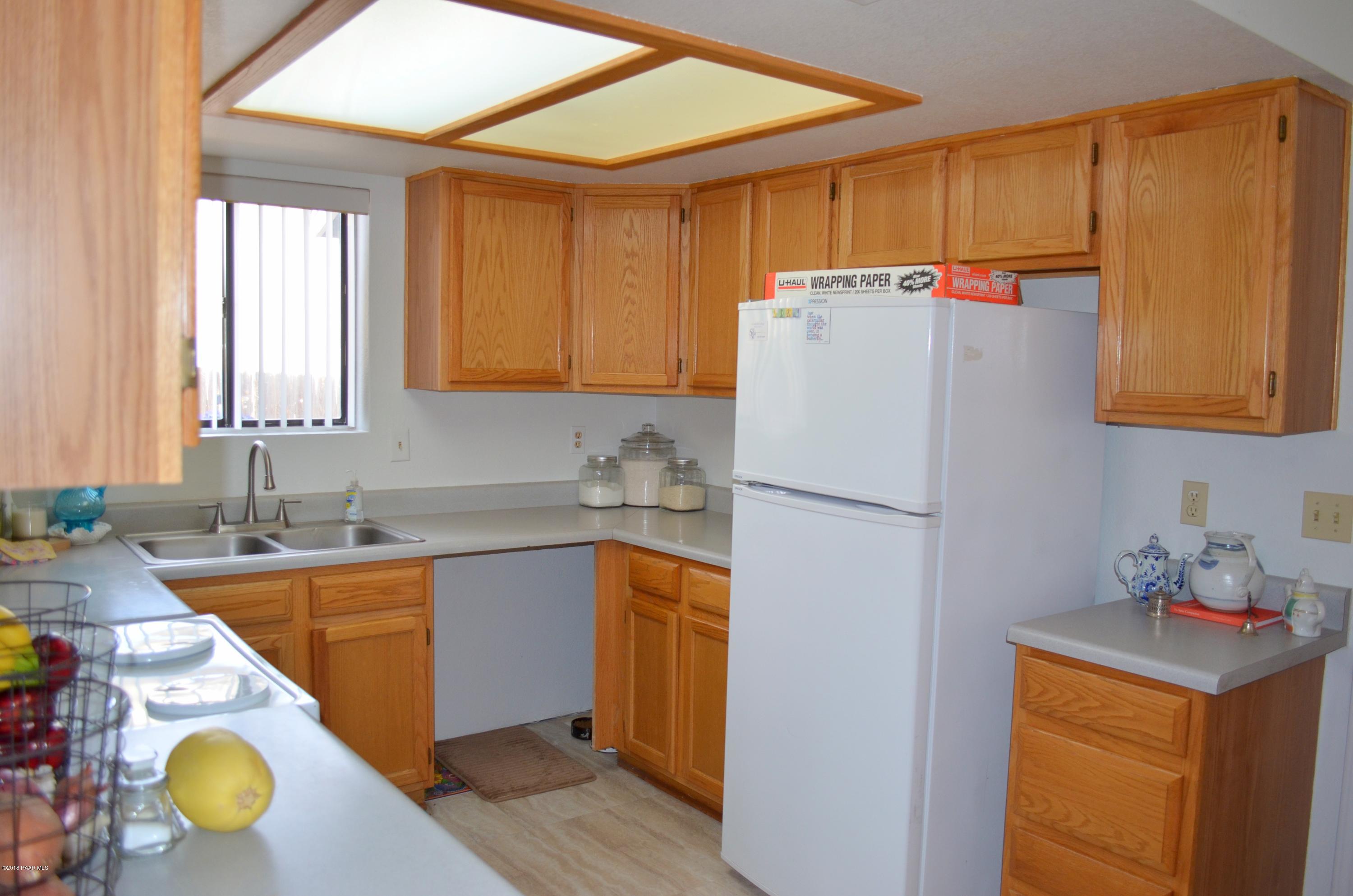4660 North Miner Road Prescott Valley, AZ 86314 - Photo 8 of 20 a white refrigerator freezer sitting inside of a kitchen