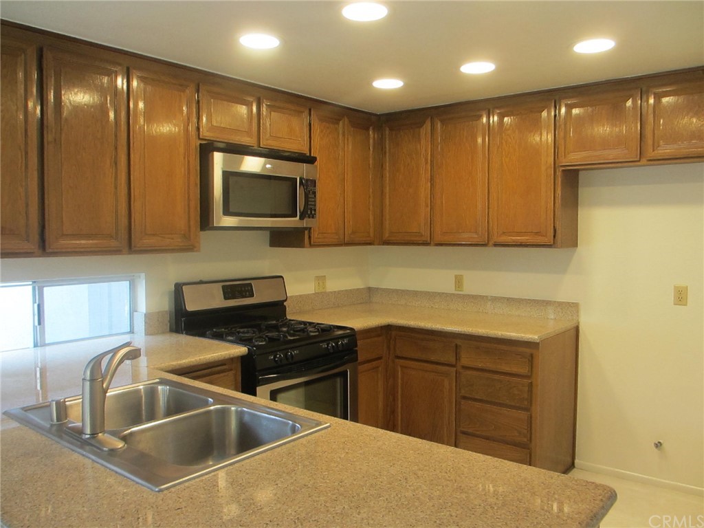 12 Brookdale Irvine, CA 92604 - Photo 3 of 28 a kitchen that has a sink cabinets counter space and stainless steel appliances