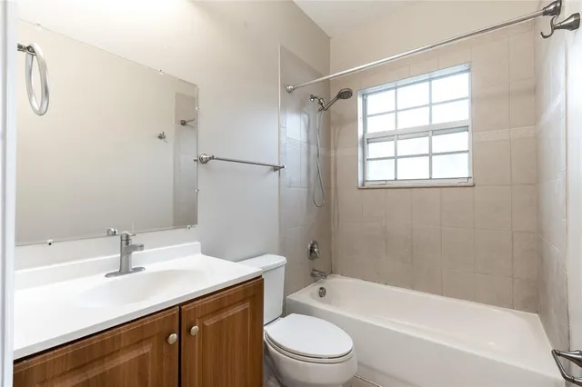 a bathroom with a granite countertop sink a toilet and shower
