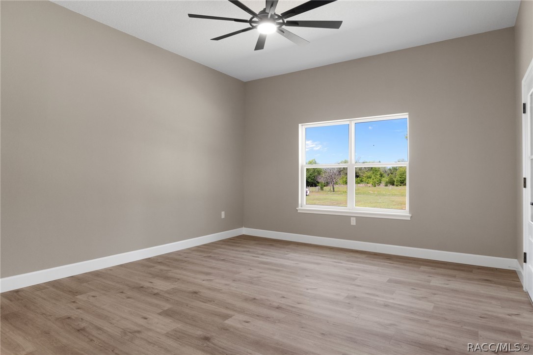 4530 South Florida Avenue Inverness, FL 34450 - Photo 16 of 100 an empty room with wooden floor and windows