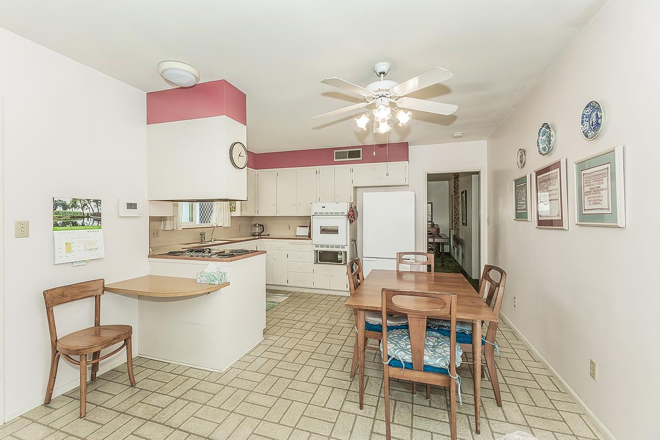 1416 South Church Avenue Reedley, CA 93654 - Photo 12 of 41 a kitchen with a dining table chairs and white cabinets
