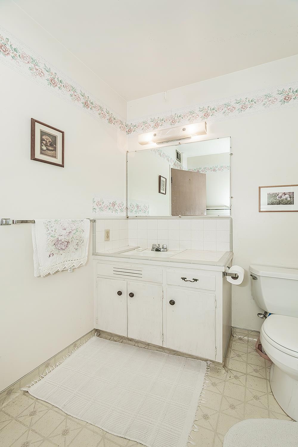 1416 South Church Avenue Reedley, CA 93654 - Photo 29 of 41 a spacious bathroom with a toilet sink and mirror