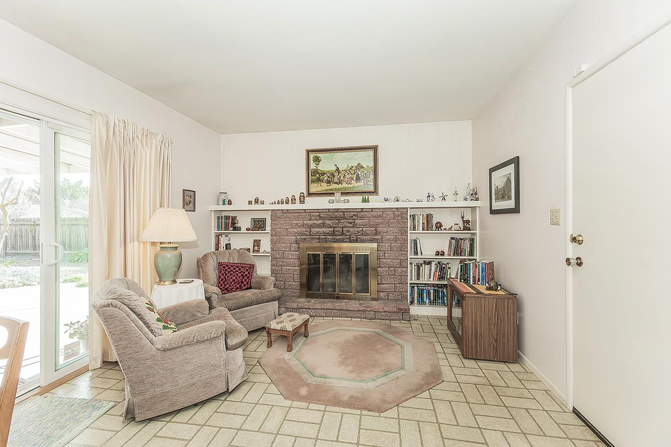 1416 South Church Avenue Reedley, CA 93654 - Photo 9 of 41 a living room with furniture a fireplace and a floor to ceiling window