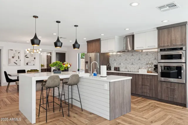 a large white kitchen with lots of counter space and furniture