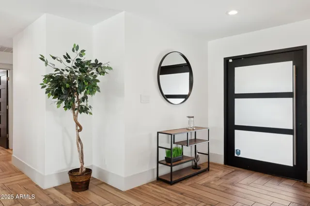 a view of a hallway with wooden floor and a window