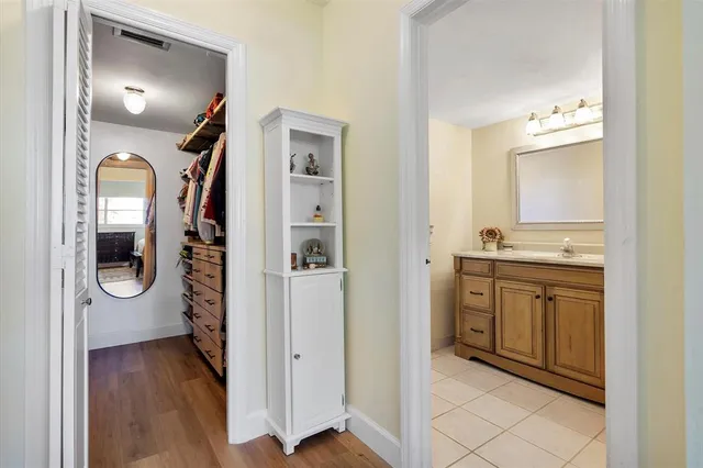 a view of a hallway with wooden floor cabinet and entryway