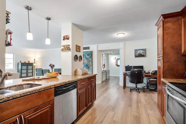 a kitchen with granite countertop a sink appliances and cabinets