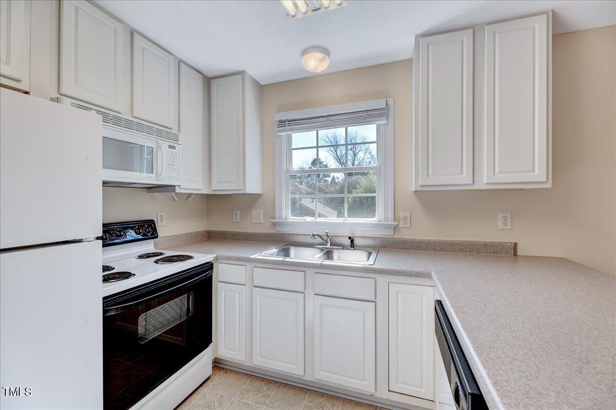 201 Brooks Avenue Raleigh, NC 27607 - Photo 28 of 44 a kitchen with white cabinets appliances a sink and a window