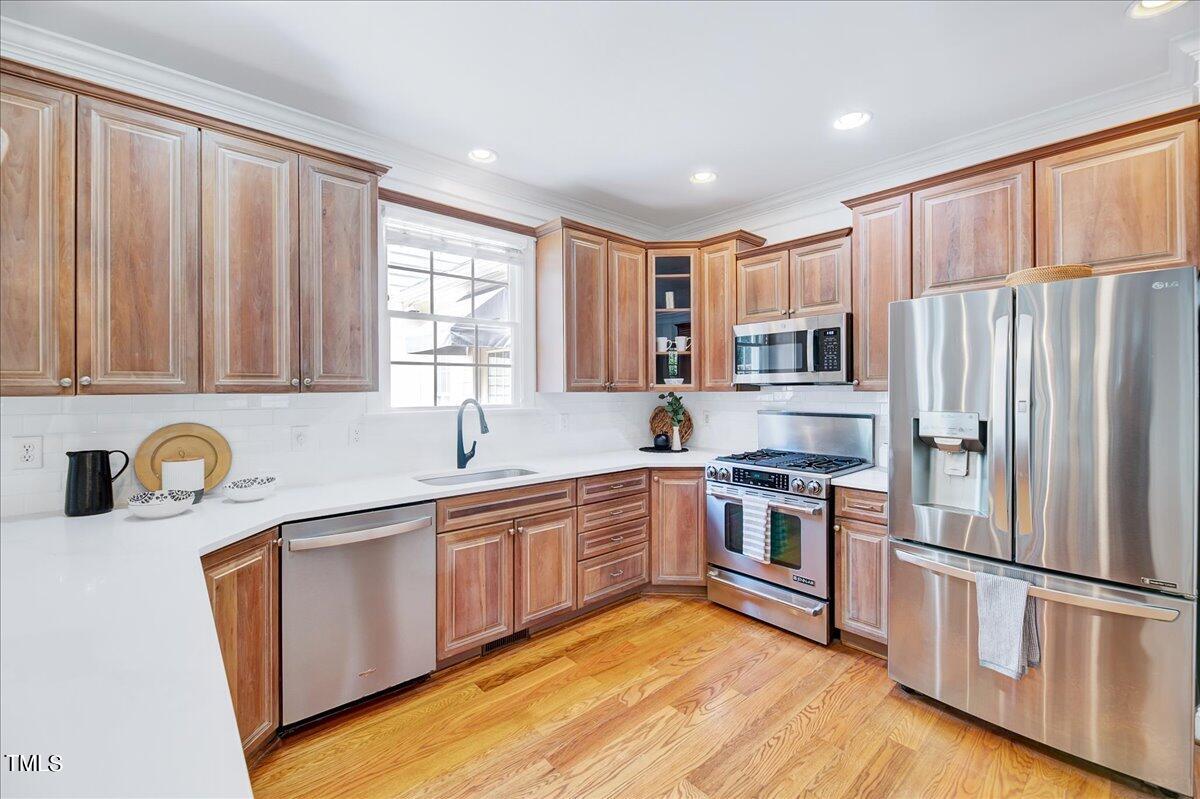 201 Brooks Avenue Raleigh, NC 27607 - Photo 9 of 44 a kitchen with stainless steel appliances granite countertop a refrigerator a sink dishwasher a stove top oven a refrigerator with white cabinets and wooden floor