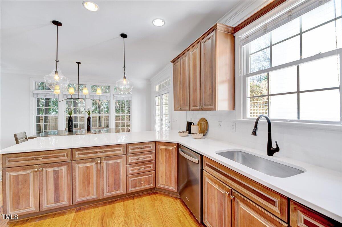 201 Brooks Avenue Raleigh, NC 27607 - Photo 10 of 44 a kitchen with stainless steel appliances granite countertop a sink a stove and a wooden floor next to a window