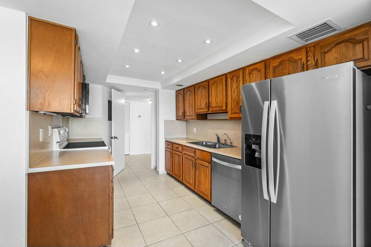 4001 North Ocean Boulevard, Unit 1503 Boca Raton, FL 33431 - Photo 15 of 46 a kitchen with stainless steel appliances granite countertop a refrigerator a stove top oven a sink and dishwasher