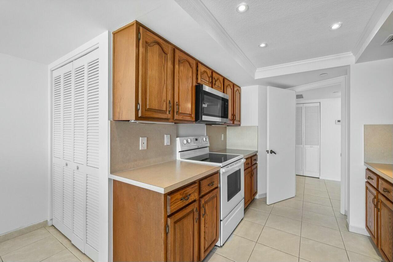 4001 North Ocean Boulevard, Unit 1503 Boca Raton, FL 33431 - Photo 16 of 46 a kitchen that has a sink and a stove in it