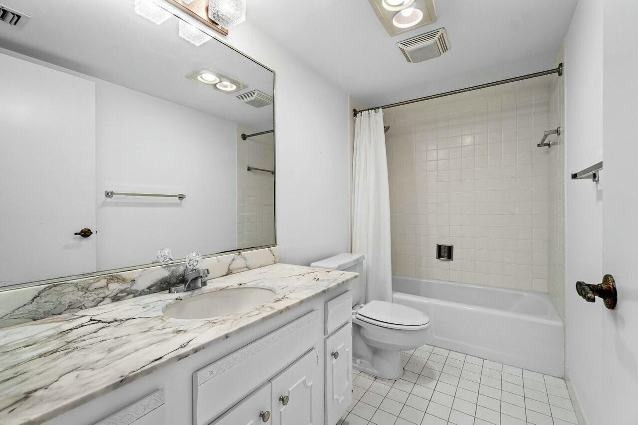 4001 North Ocean Boulevard, Unit 1503 Boca Raton, FL 33431 - Photo 31 of 46 a bathroom with a granite countertop sink a toilet and shower
