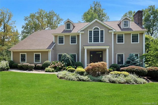 a front view of a house with a garden and plants