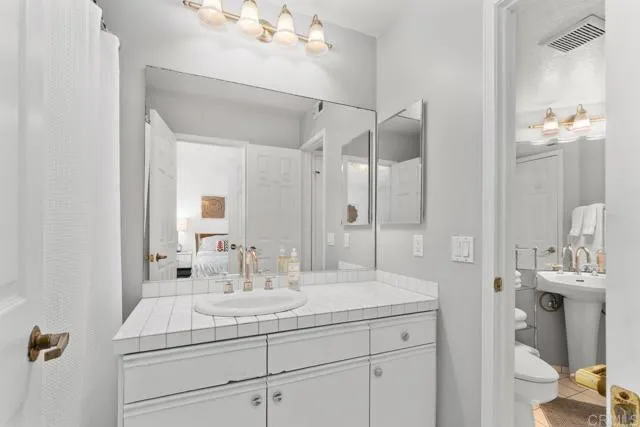 892 Del Mar Downs Road Solana Beach, CA 92075 - Photo 13 of 19 a bathroom with a sink vanity granite and a mirror