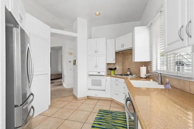 892 Del Mar Downs Road Solana Beach, CA 92075 - Photo 7 of 19 a large kitchen with a refrigerator a sink a stove a washer and dryer