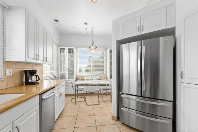 892 Del Mar Downs Road Solana Beach, CA 92075 - Photo 8 of 19 a kitchen with stainless steel appliances a refrigerator sink and cabinets