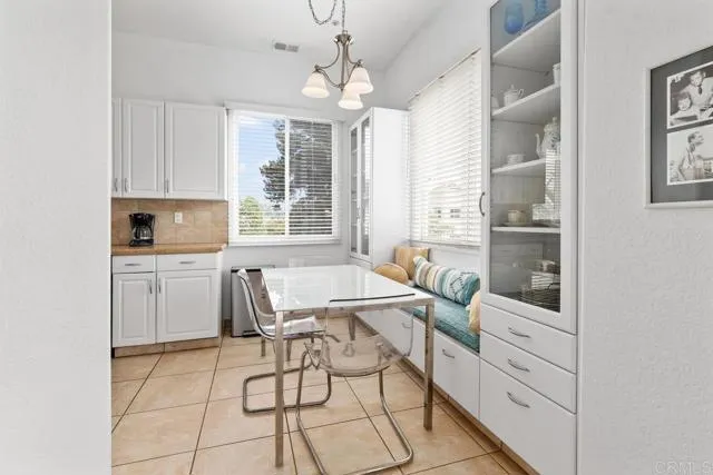 892 Del Mar Downs Road Solana Beach, CA 92075 - Photo 9 of 19 a kitchen with a dining table chairs and cabinets