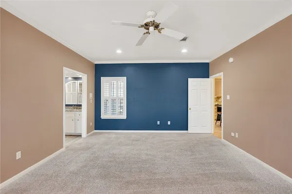 a view of a livingroom with a chandelier fan and windows