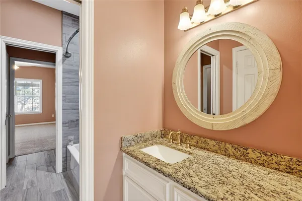 a bathroom with a granite countertop sink and a mirror