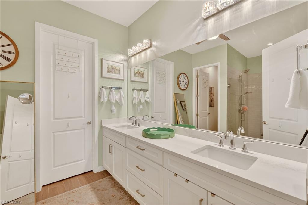 14628 Kingfisher Loop Naples, FL 34120 - Photo 15 of 39 a bathroom with a double vanity sink and a mirror