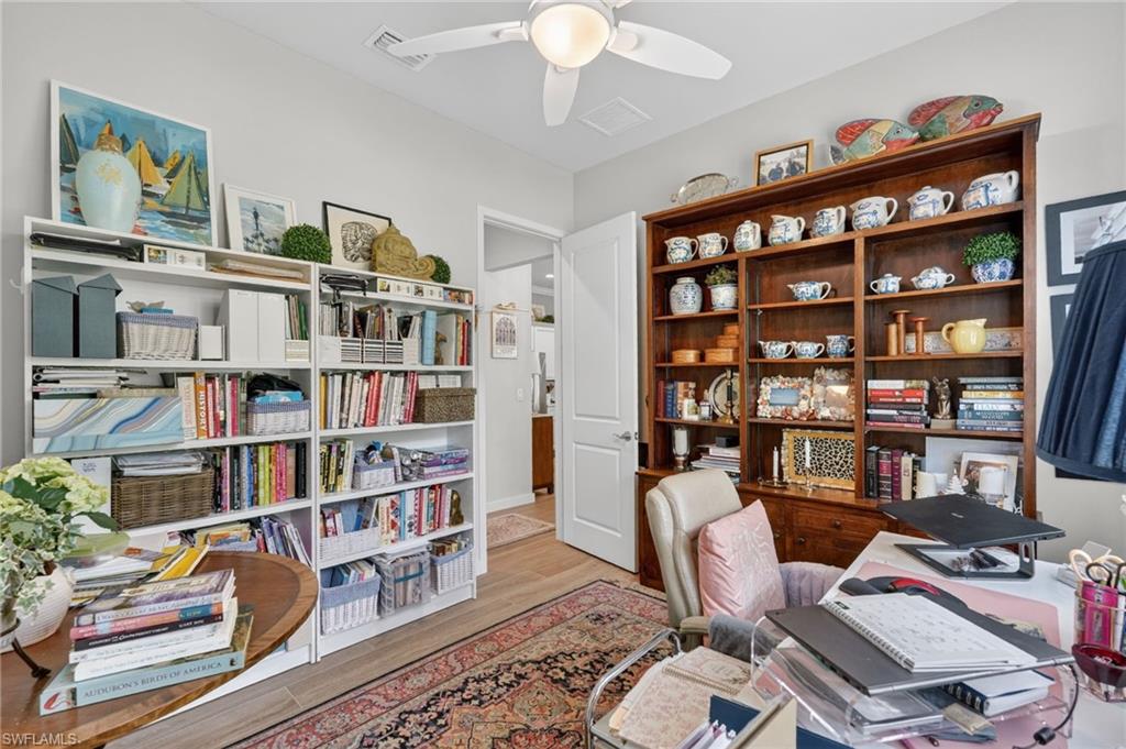14628 Kingfisher Loop Naples, FL 34120 - Photo 21 of 39 a work room with bookshelf and a workspace