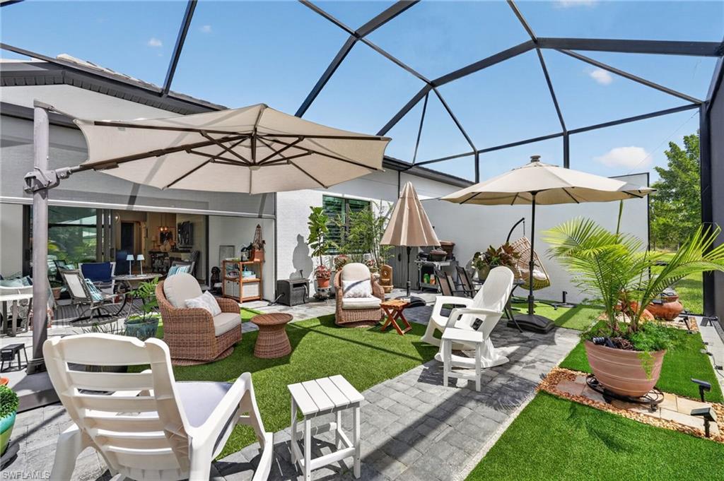 14628 Kingfisher Loop Naples, FL 34120 - Photo 27 of 39 a view of an chairs and table under an umbrella