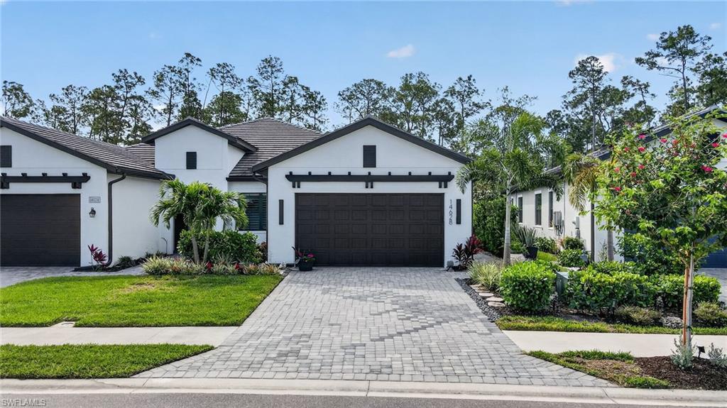 14628 Kingfisher Loop Naples, FL 34120 - Photo 29 of 39 a front view of a house with a yard and garage