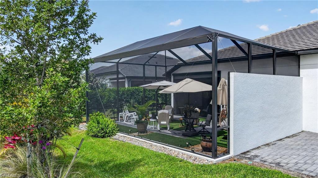 14628 Kingfisher Loop Naples, FL 34120 - Photo 31 of 39 a view of a patio with table and chairs under an umbrella