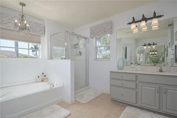 a spacious bathroom with a tub sink and a mirror