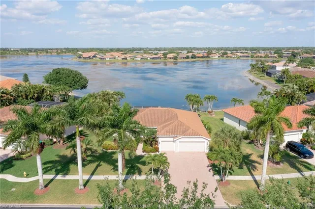 an aerial view of ocean and residential houses with outdoor space